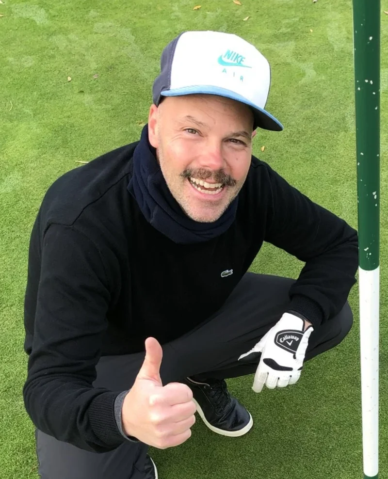 Björn Rosenthal, founder of TeeSetGo, kneeling on the green giving a thumbs up